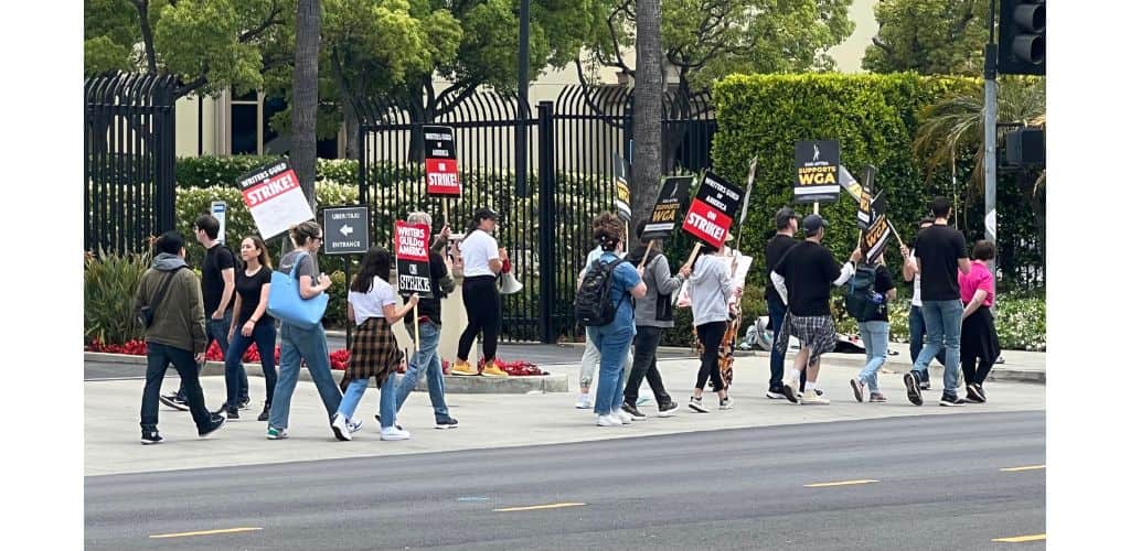 writers and actors on strike carrying signs in protest